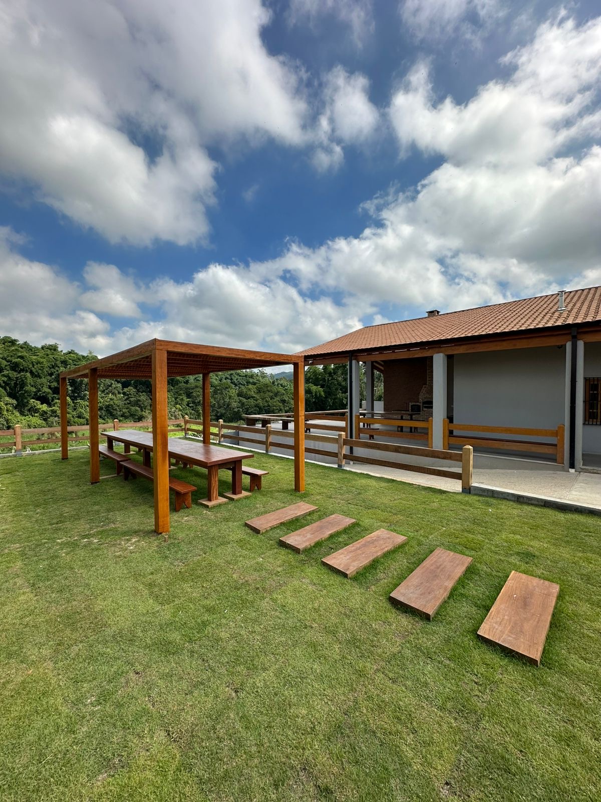 Jardim gramado com pergolado e vista para a natureza