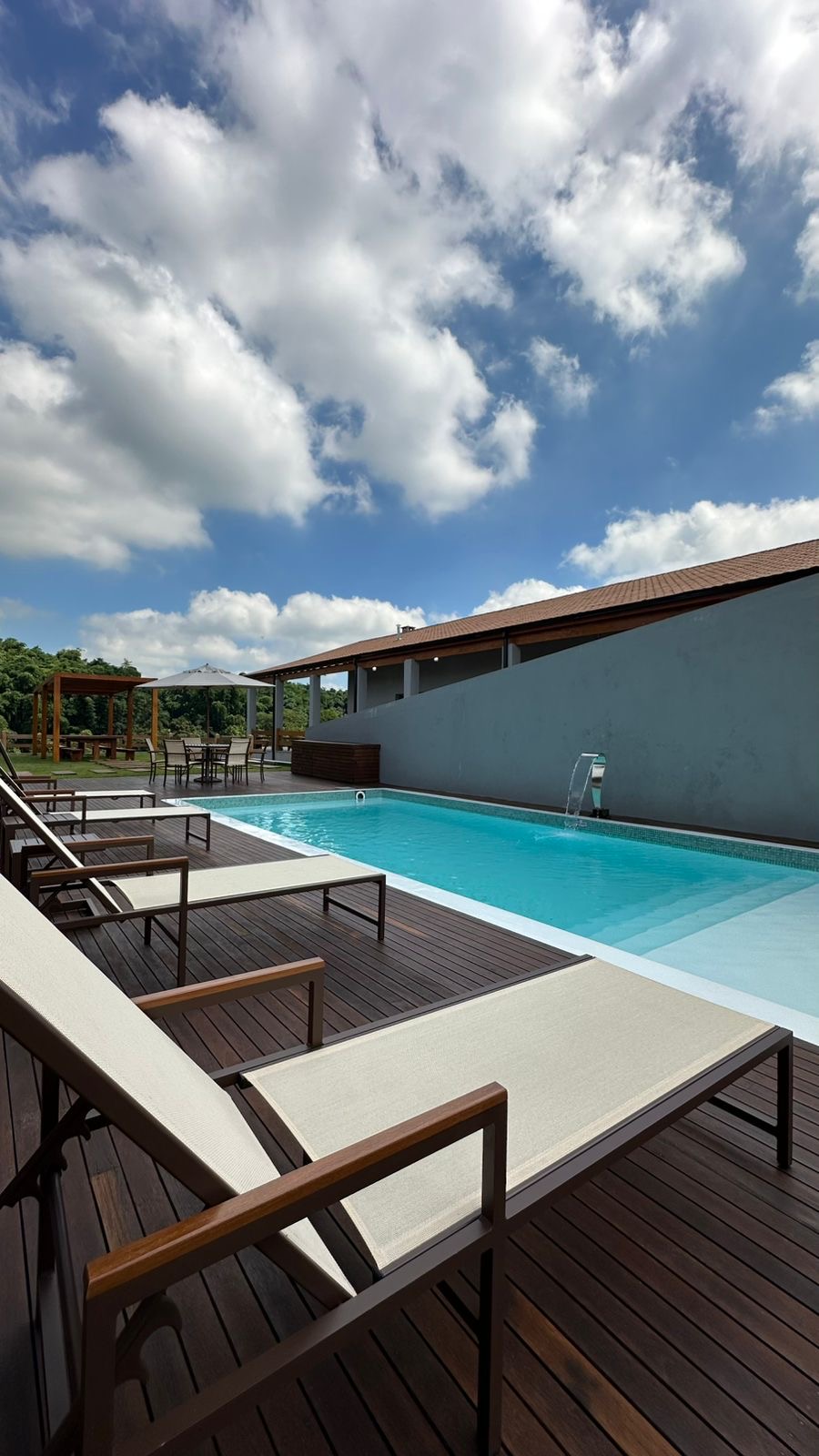 Piscina com cascata e deck de madeira