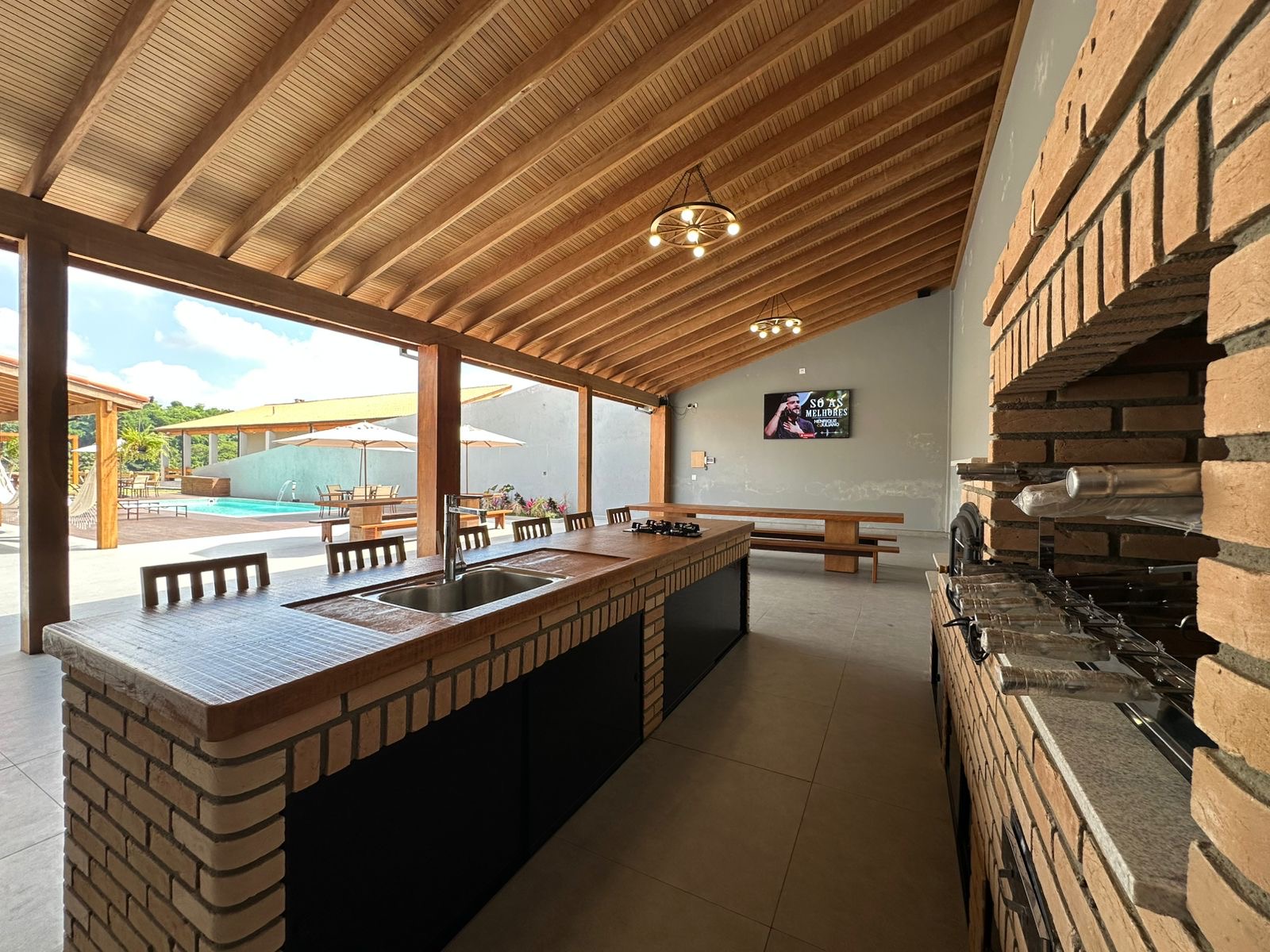 Bancada da área gourmet e churrasqueira com vista para a piscina