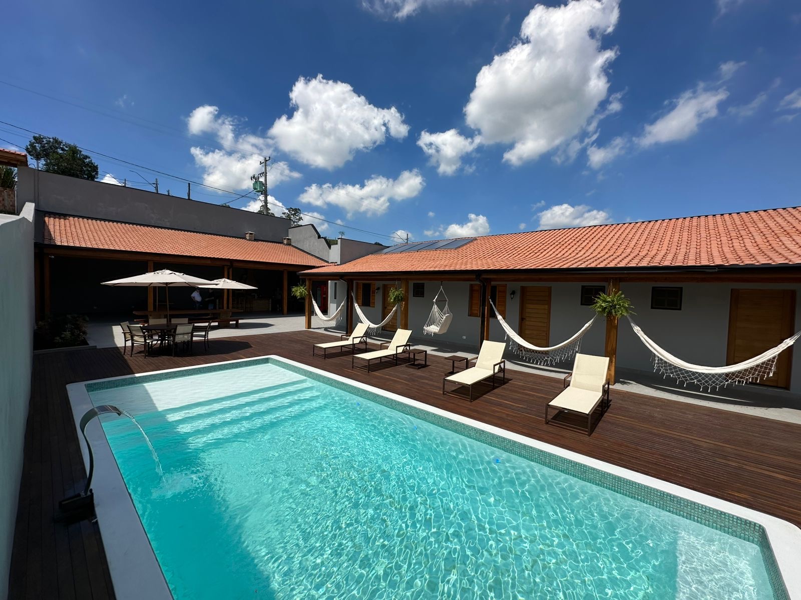 Vista ampla da piscina e varanda com redes da Chácara ABW